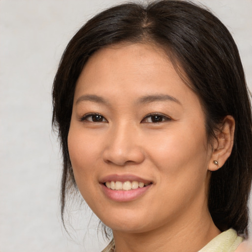 Joyful asian young-adult female with medium  brown hair and brown eyes