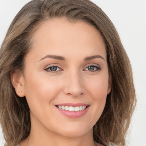 Joyful white young-adult female with long  brown hair and grey eyes