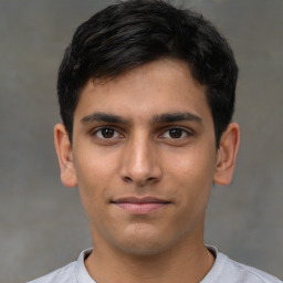 Joyful latino young-adult male with short  brown hair and brown eyes