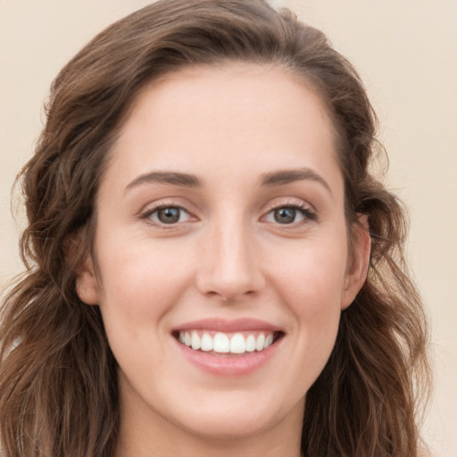 Joyful white young-adult female with long  brown hair and blue eyes