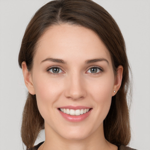 Joyful white young-adult female with medium  brown hair and grey eyes