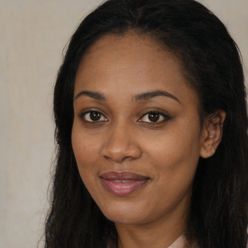 Joyful black young-adult female with long  brown hair and brown eyes