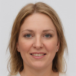 Joyful white adult female with medium  brown hair and grey eyes