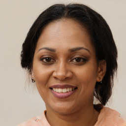 Joyful black adult female with medium  brown hair and brown eyes