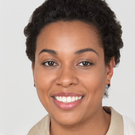 Joyful black young-adult female with short  brown hair and brown eyes