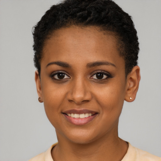 Joyful black young-adult female with short  brown hair and brown eyes
