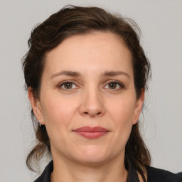 Joyful white adult female with medium  brown hair and grey eyes