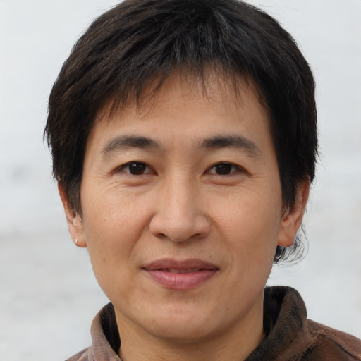 Joyful asian adult male with short  brown hair and brown eyes