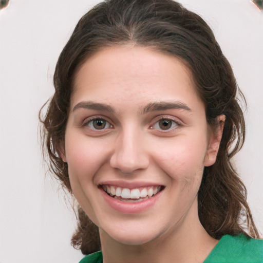 Joyful white young-adult female with medium  brown hair and green eyes