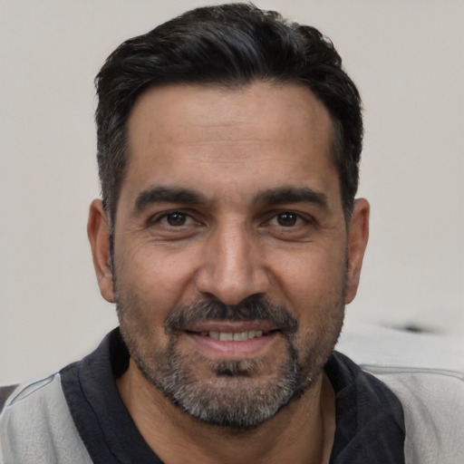 Joyful white adult male with short  black hair and brown eyes