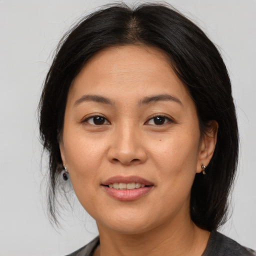 Joyful asian adult female with medium  brown hair and brown eyes
