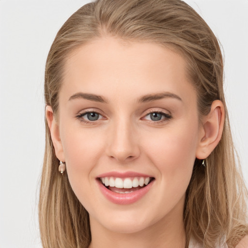 Joyful white young-adult female with long  brown hair and blue eyes