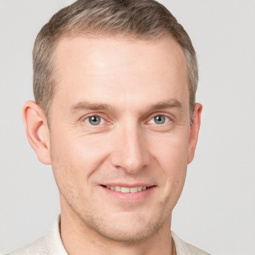 Joyful white adult male with short  brown hair and grey eyes