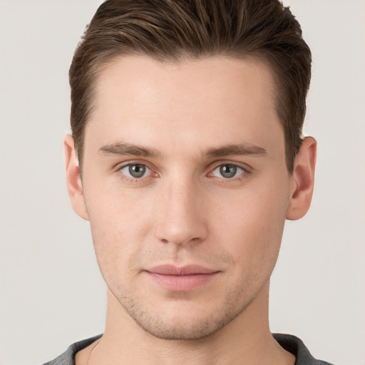 Joyful white young-adult male with short  brown hair and grey eyes