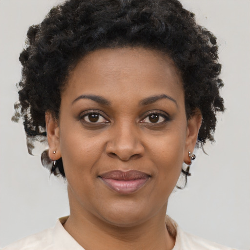 Joyful black adult female with short  brown hair and brown eyes