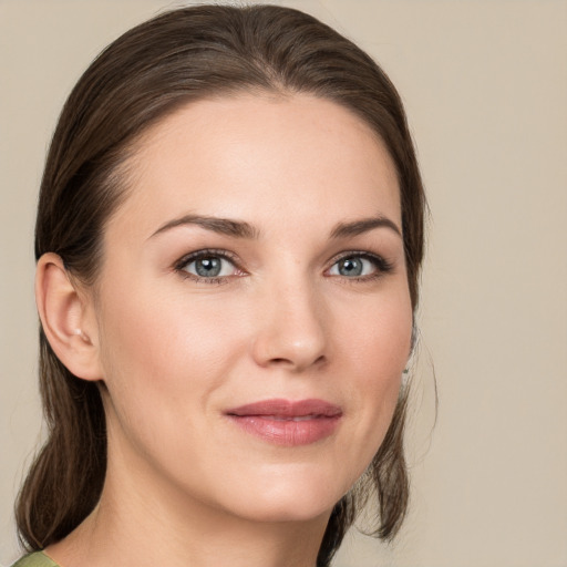 Joyful white young-adult female with medium  brown hair and green eyes