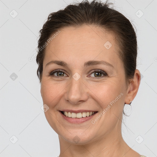 Joyful white young-adult female with medium  brown hair and grey eyes