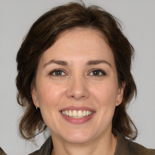 Joyful white young-adult female with medium  brown hair and green eyes