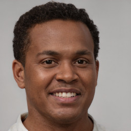 Joyful latino young-adult male with short  brown hair and brown eyes