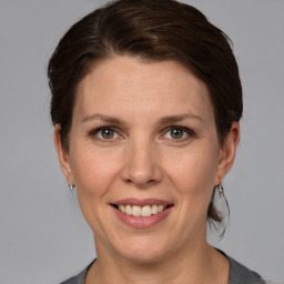 Joyful white adult female with medium  brown hair and grey eyes