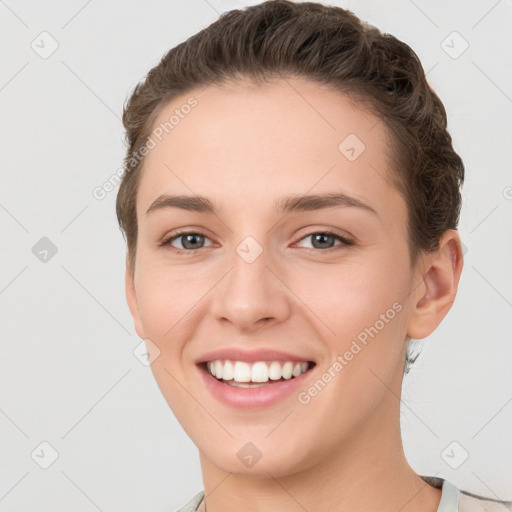 Joyful white young-adult female with short  brown hair and grey eyes