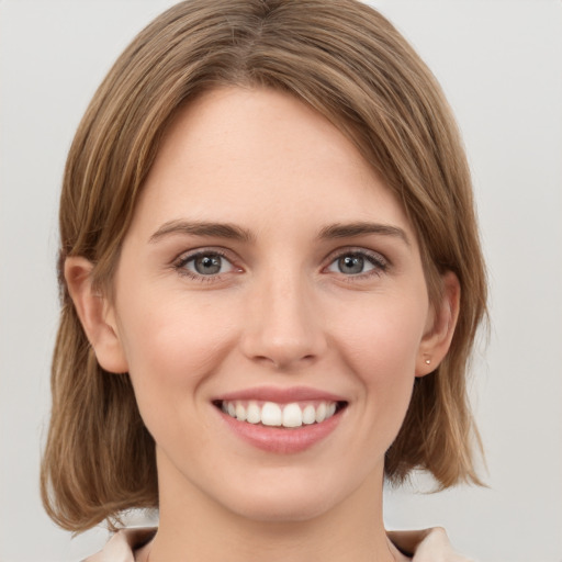 Joyful white young-adult female with medium  brown hair and green eyes