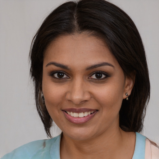Joyful black young-adult female with medium  brown hair and brown eyes