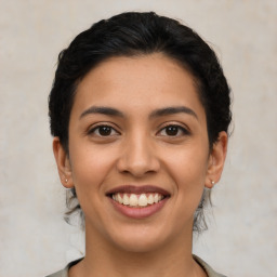 Joyful latino young-adult female with medium  brown hair and brown eyes