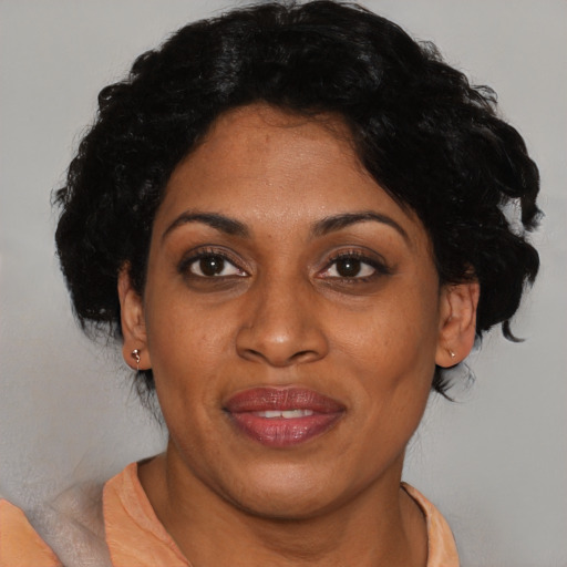 Joyful black adult female with medium  black hair and brown eyes