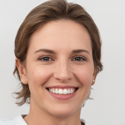 Joyful white young-adult female with medium  brown hair and grey eyes