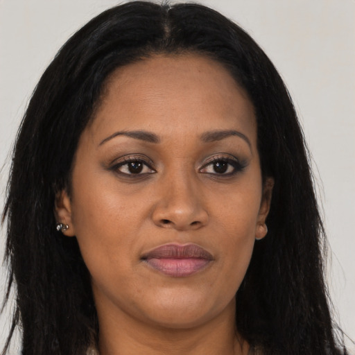 Joyful black young-adult female with long  brown hair and brown eyes