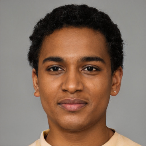 Joyful black young-adult male with short  black hair and brown eyes