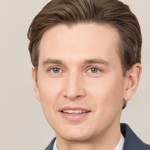 Joyful white young-adult male with short  brown hair and grey eyes