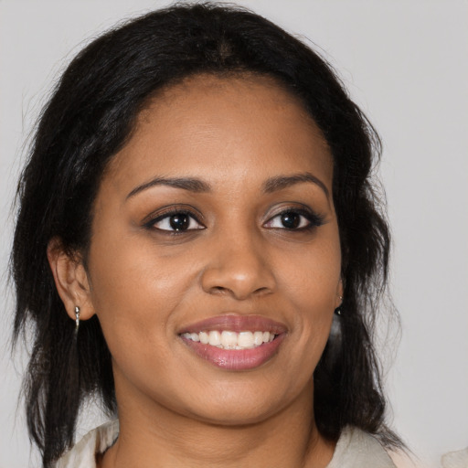 Joyful black young-adult female with long  brown hair and brown eyes
