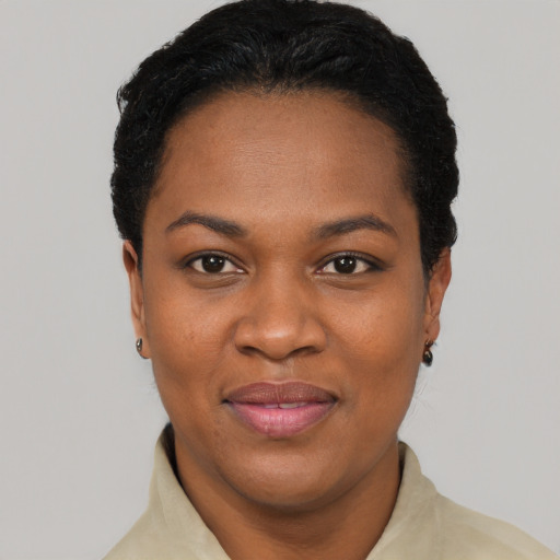 Joyful black young-adult female with short  black hair and brown eyes