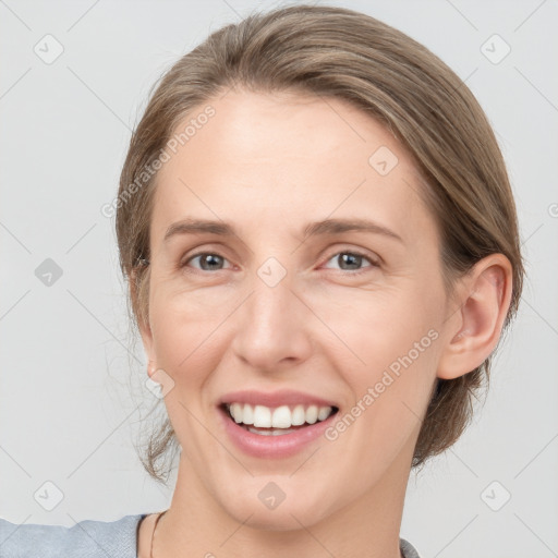 Joyful white young-adult female with medium  brown hair and grey eyes