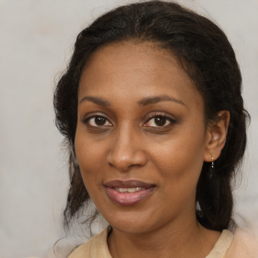 Joyful black adult female with medium  brown hair and brown eyes