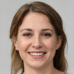 Joyful white young-adult female with medium  brown hair and grey eyes