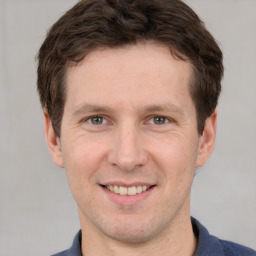 Joyful white adult male with short  brown hair and grey eyes