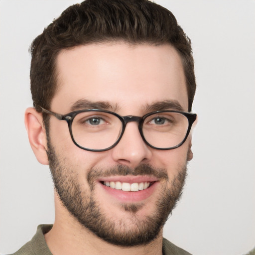 Joyful white young-adult male with short  brown hair and green eyes