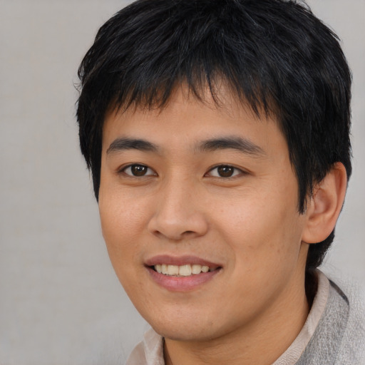 Joyful asian young-adult male with short  black hair and brown eyes
