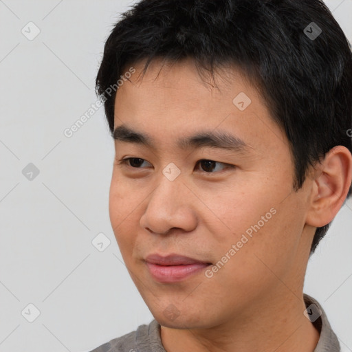 Joyful asian young-adult male with short  black hair and brown eyes