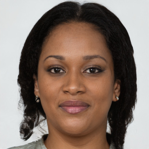 Joyful black adult female with long  brown hair and brown eyes