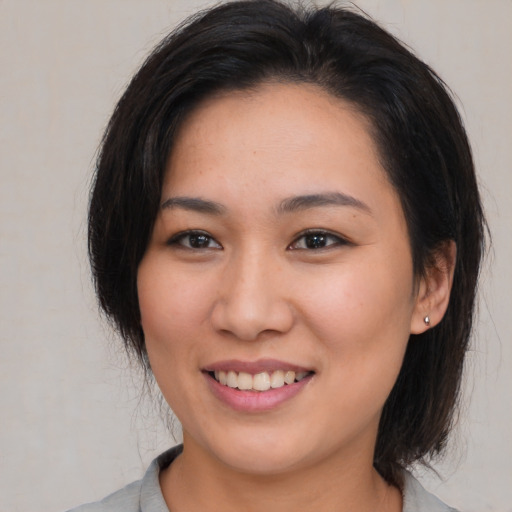 Joyful asian young-adult female with medium  brown hair and brown eyes