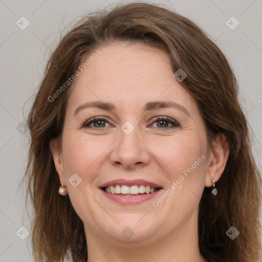 Joyful white adult female with long  brown hair and grey eyes