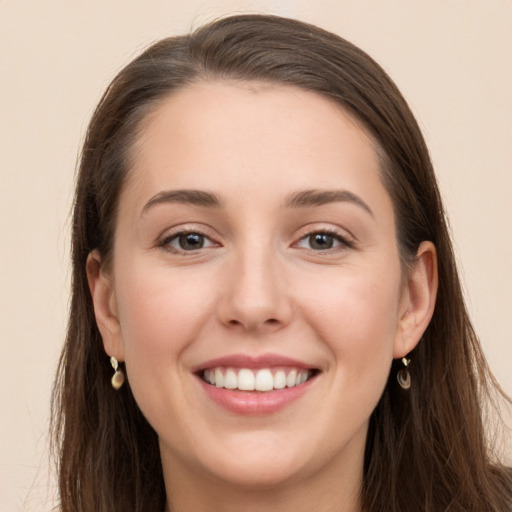 Joyful white young-adult female with long  brown hair and grey eyes