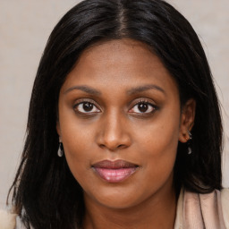 Joyful black young-adult female with long  brown hair and brown eyes