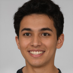 Joyful latino young-adult male with short  brown hair and brown eyes