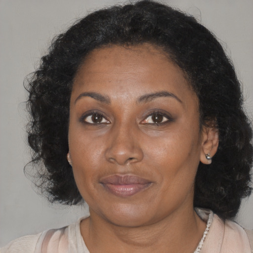 Joyful black adult female with medium  brown hair and brown eyes
