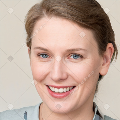 Joyful white young-adult female with medium  brown hair and blue eyes